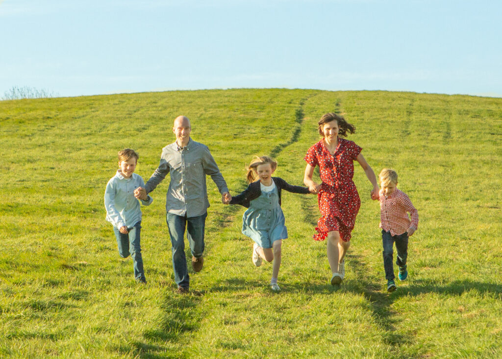 Spring family photo shoot running down a hill together